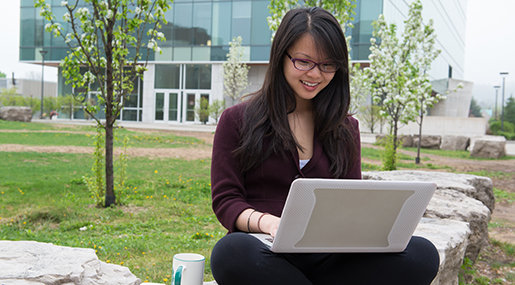 A student uses a laptop outdoors